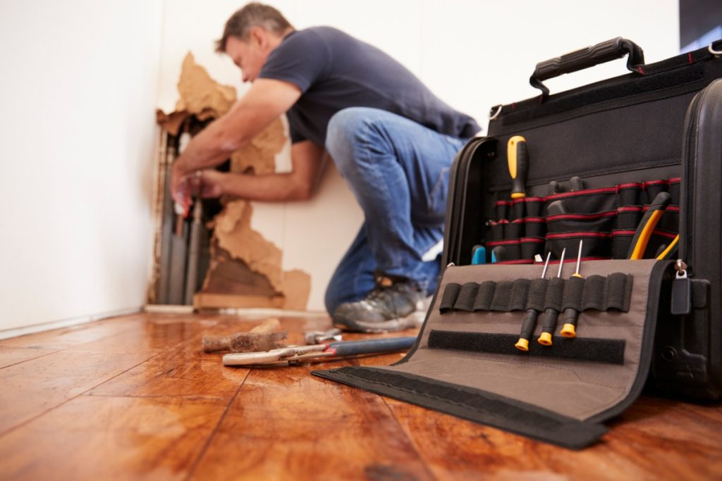 Professional handyman completing a small interior home repair for a homeowner