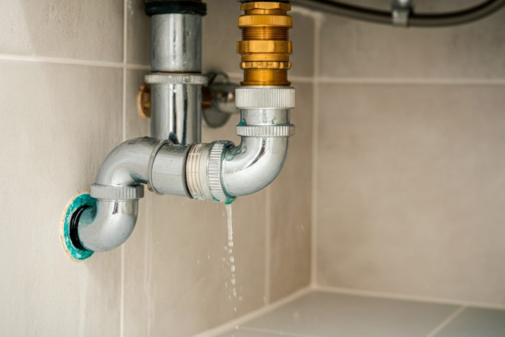 Minor plumbing leak under a sink in a Pittsburgh home during winter