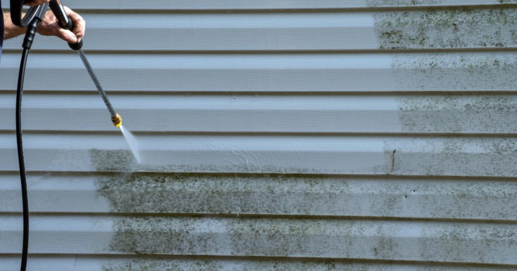 Pressure washing house siding to remove winter dirt and mildew in Pittsburgh