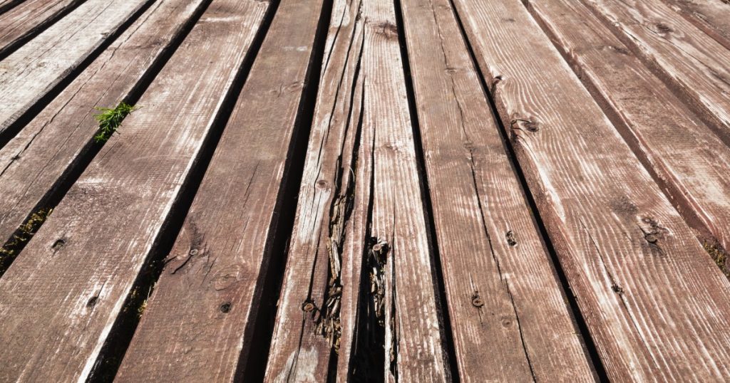 Deck board with surface cracking or soft wood damage after winter