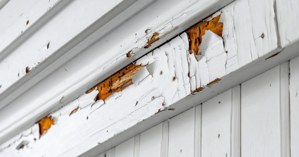 Bare wood exposed where exterior paint has worn away