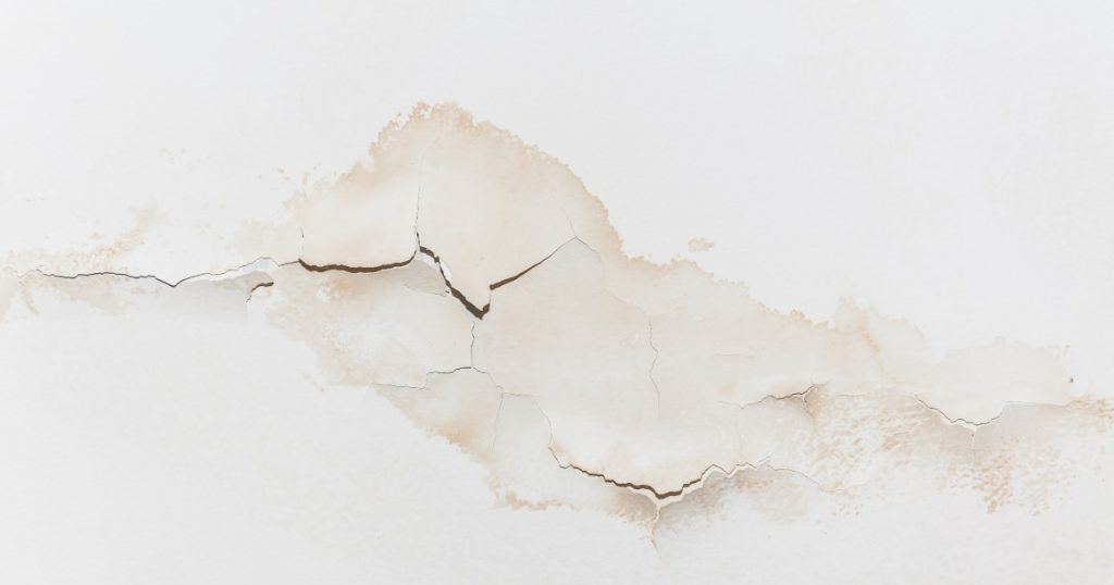 Peeling paint on an interior wall caused by water damage