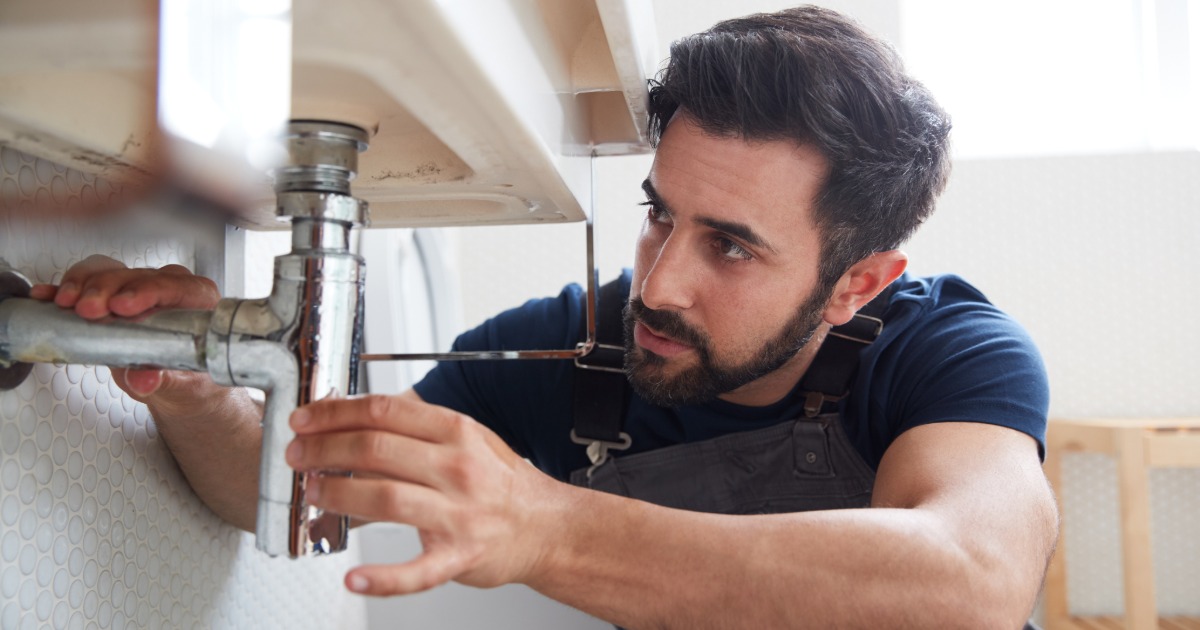 Homeowner deciding whether to repair or replace a leaking faucet
