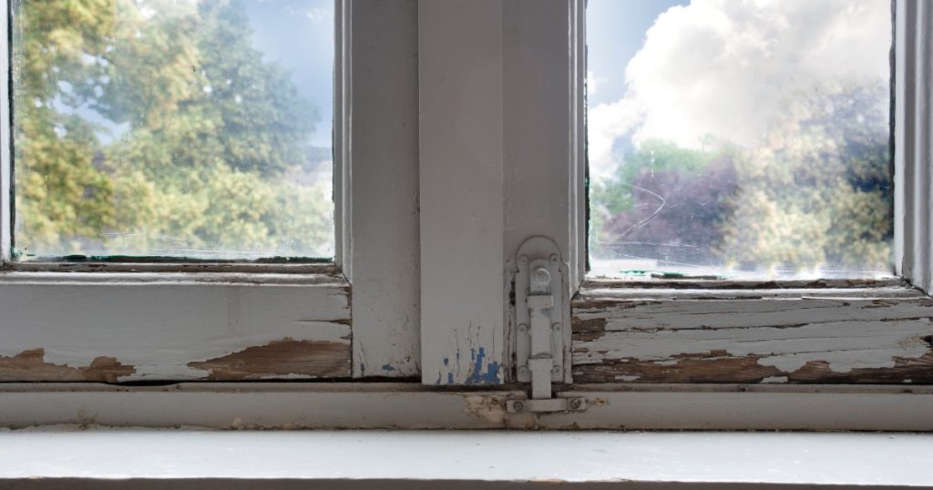 Cracked window frame and failed caulk seal after spring storm damage.