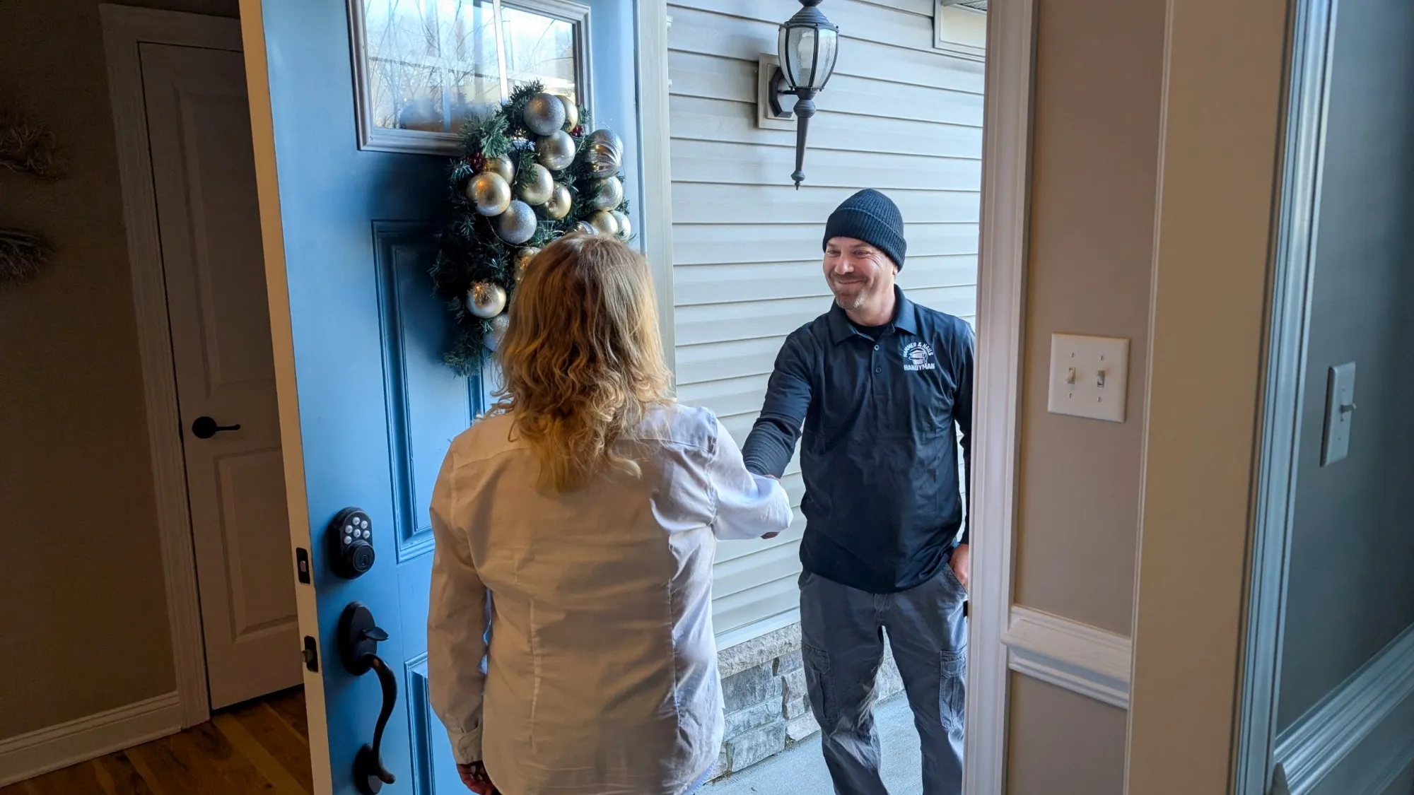 Homeowner speaking with a Hammer & Nails Handyman services technician inside her home
