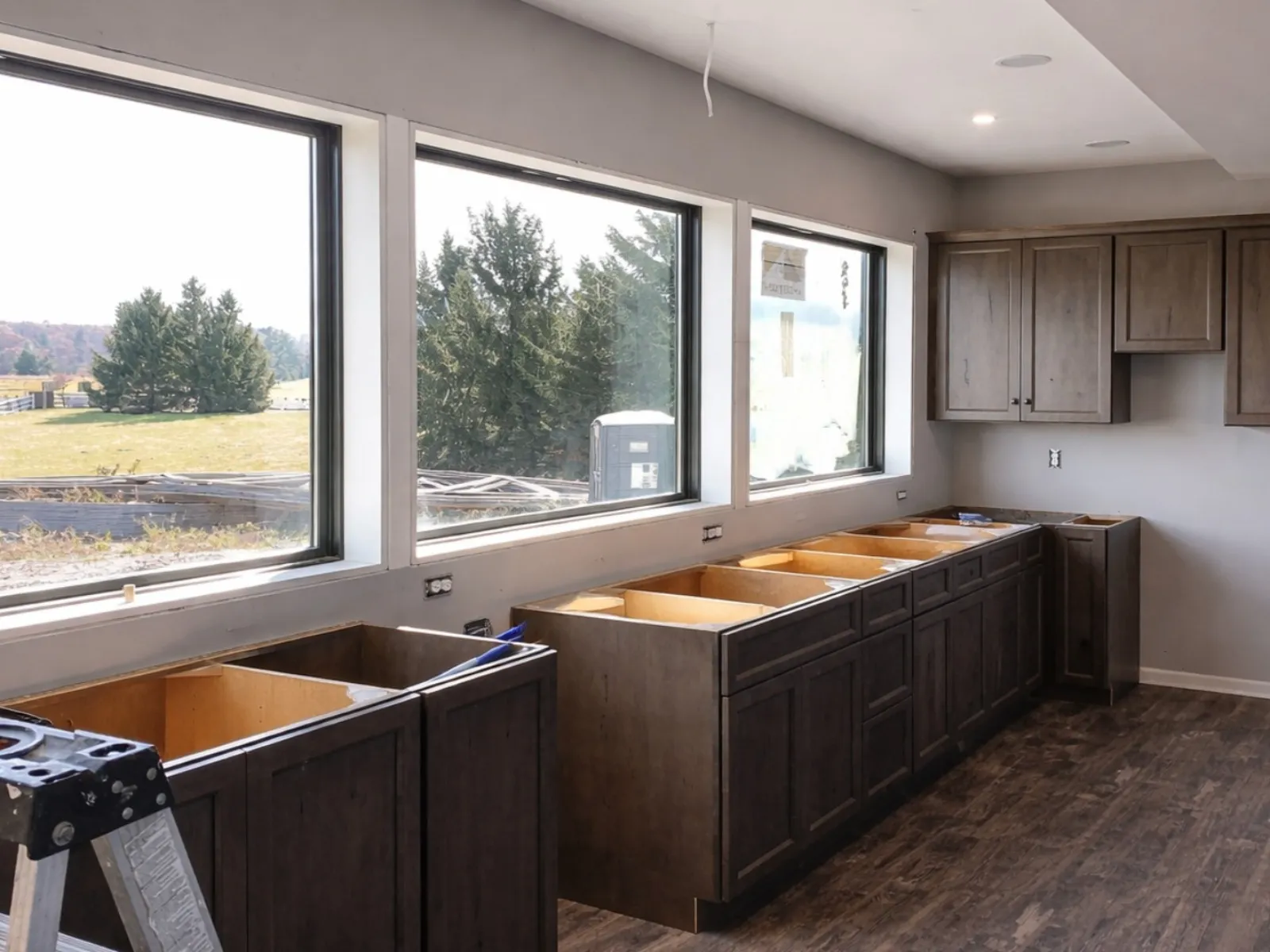 Kitchen renovation with cabinets removed beneath a row of windows