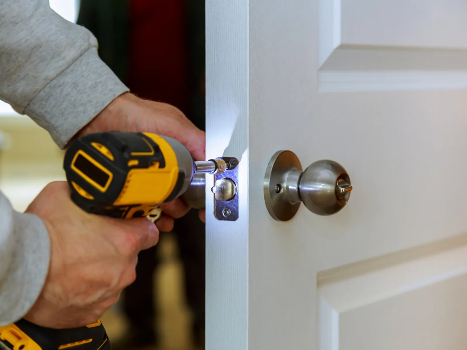 Hammer & Nails Handyman technician installing a white door and a brass knob