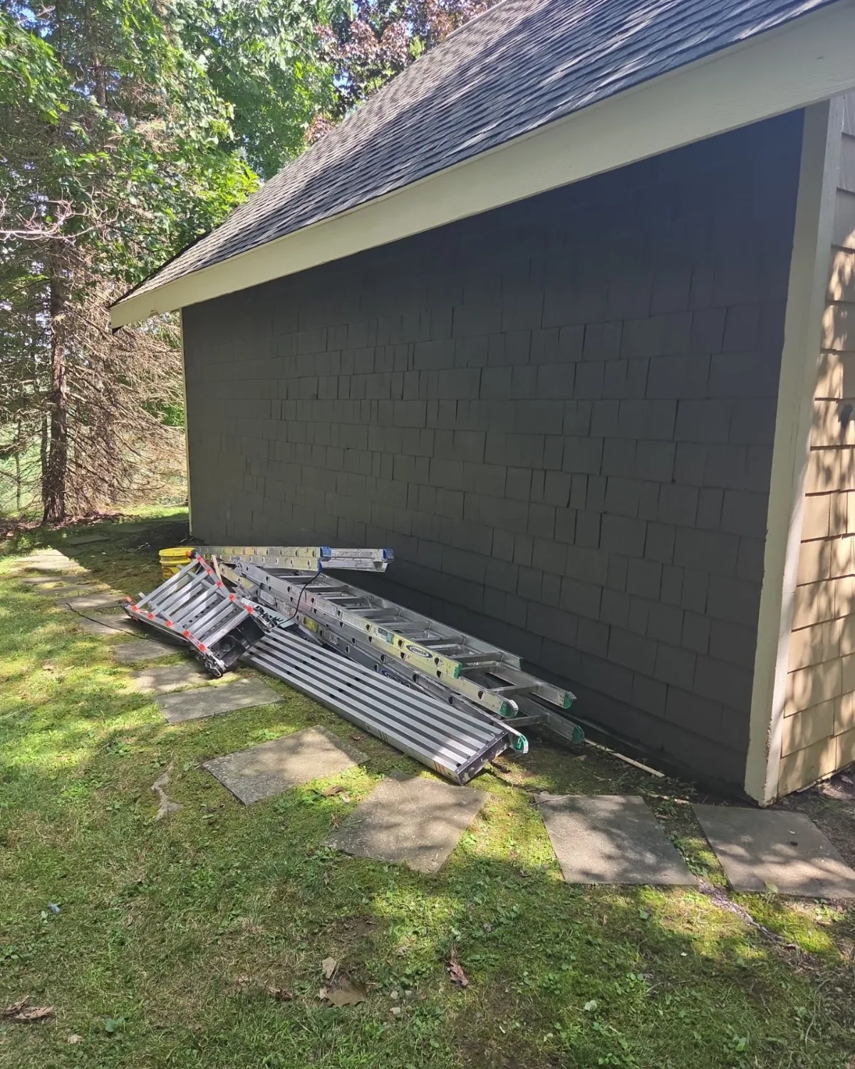Exterior wall repair along the base of a small outbuilding