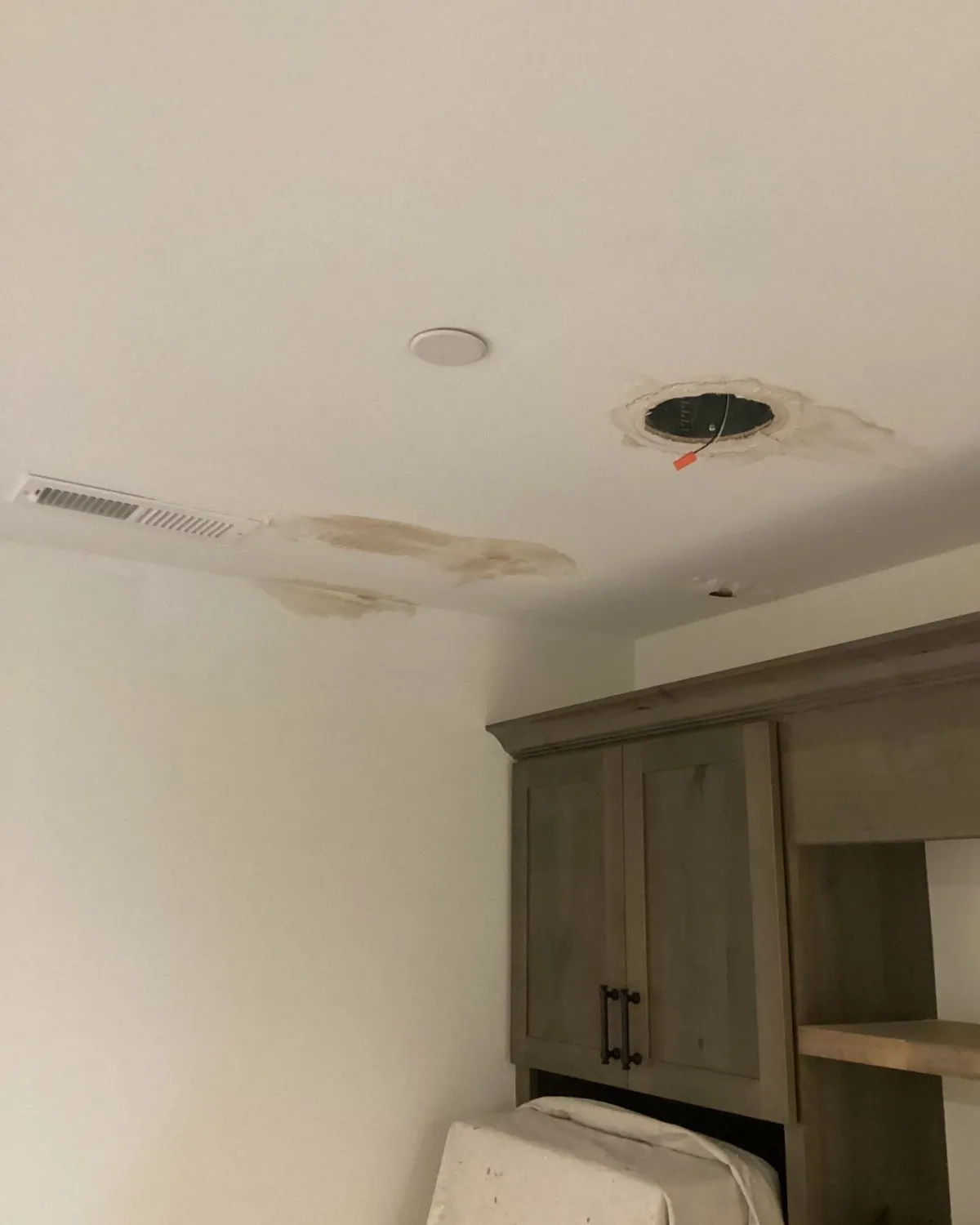 Water damaged ceiling above a gray cabinet