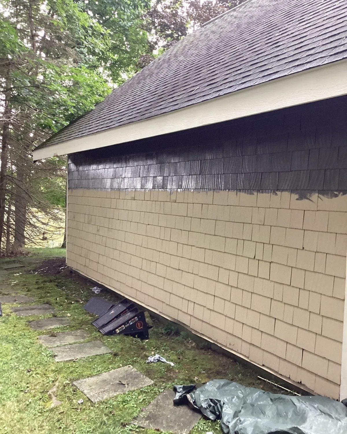 Shingle-sided outbuilding with exterior repairs in progress