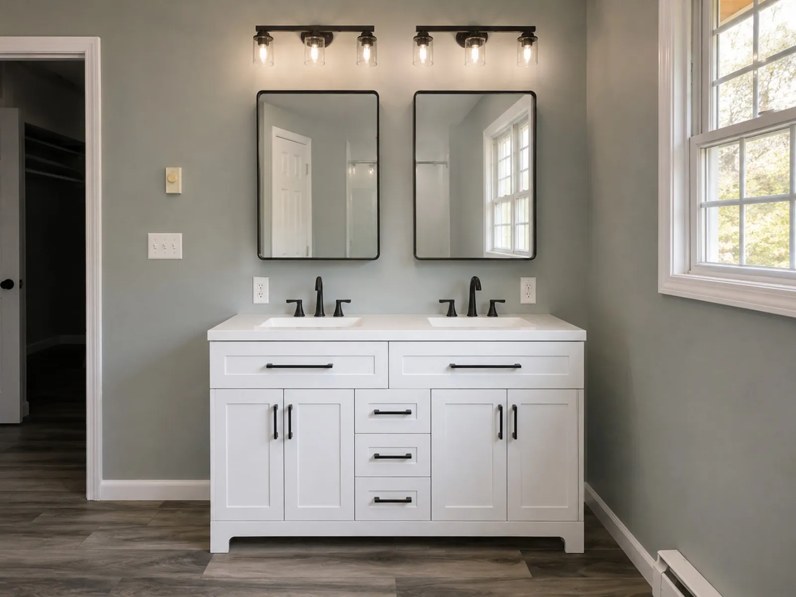Renovated bathroom with a gray vanity and black mirrors