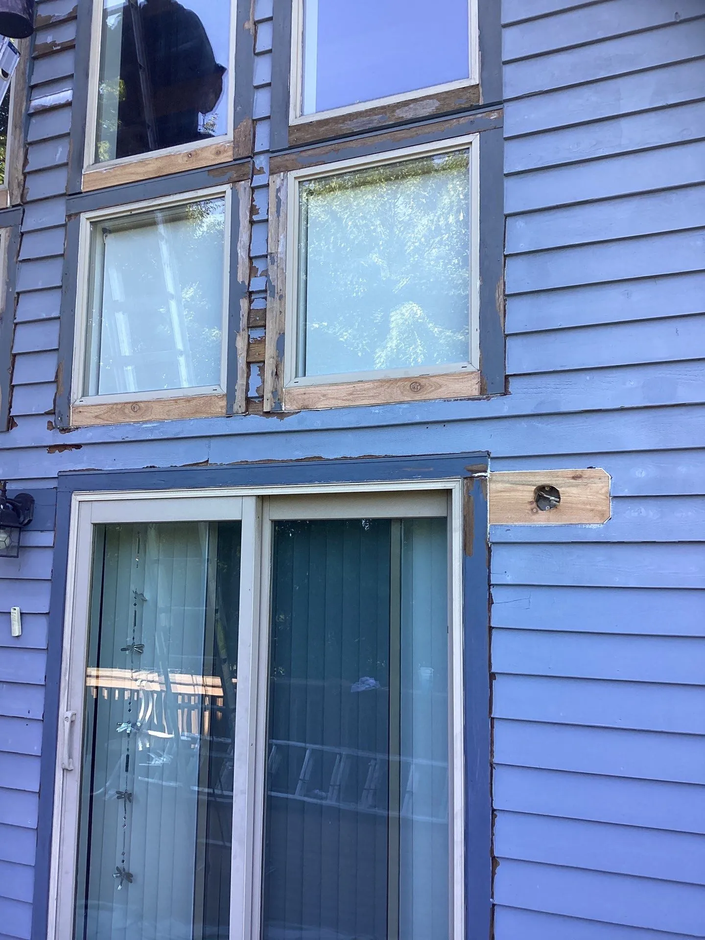 Chipped paint and glass on the exterior of a blue home