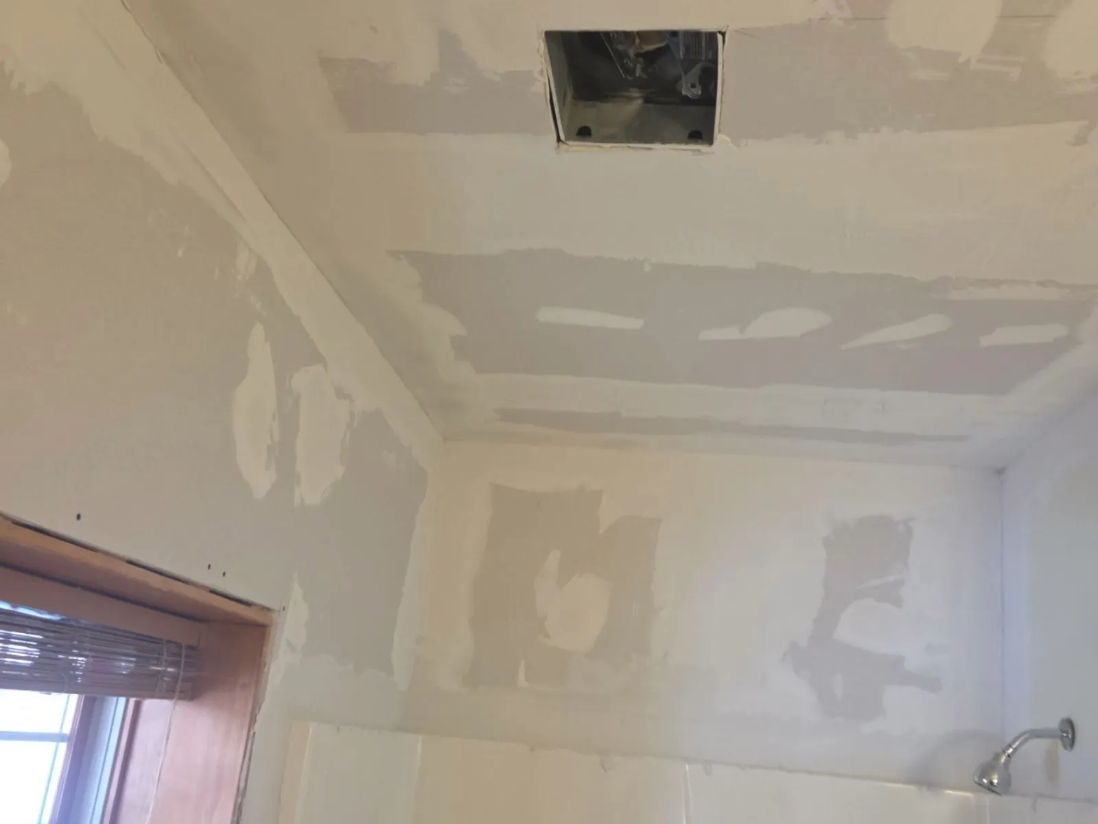 A bathroom's walls and ceiling patched and prepped before interior painting