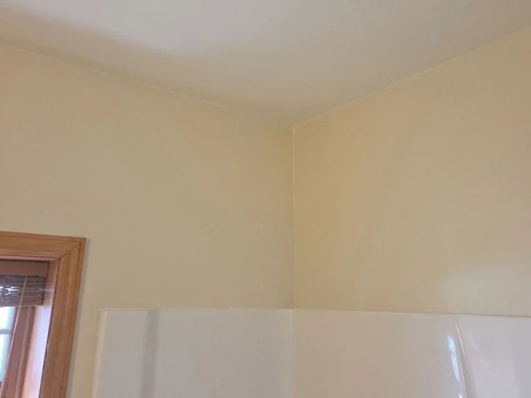 A bathroom's walls and ceiling patched, smoothed, and freshly painted.