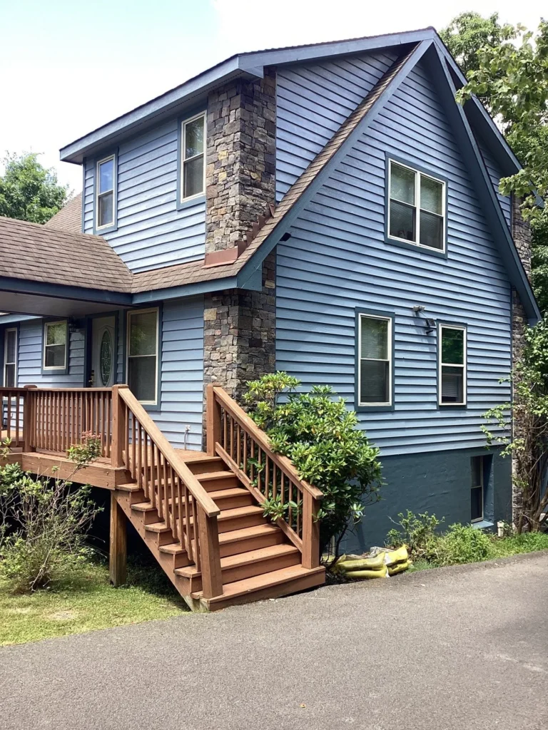 exterior painting on a blue lake house