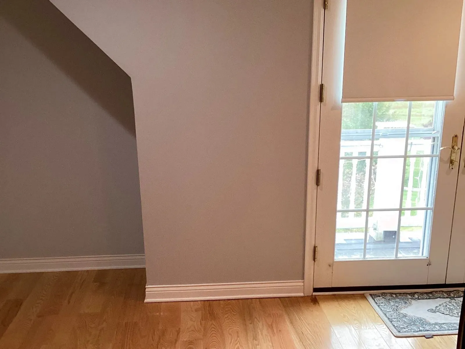Repaired interior wall with white trim beside a window